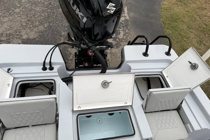Slide: The Image of 2026 Blazer Bay 2220 Fisherman boat with open storage compartments and Suzuki outboard motor. - 22