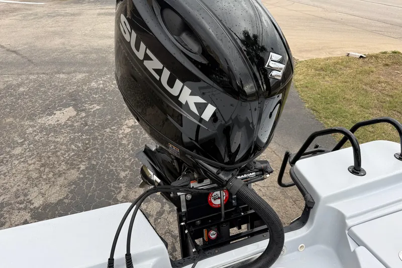 Slide: The Image of 2026 Blazer Bay 2220 Fisherman with Suzuki outboard motor, parked on pavement. - 23