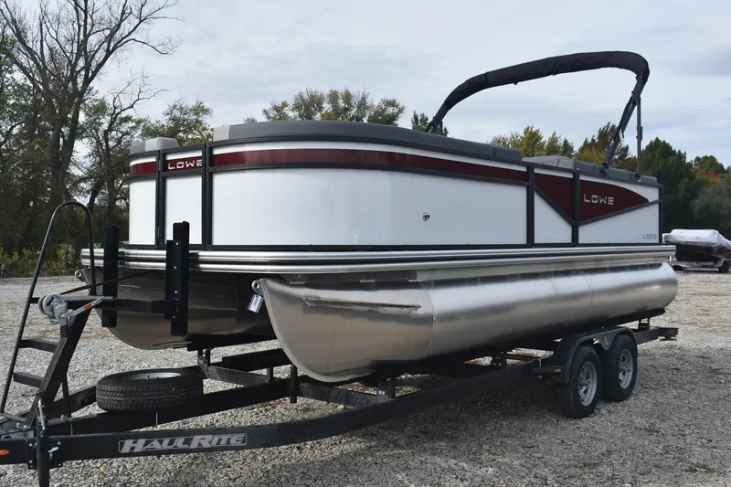Slide: The Image of 2026 Lowe LS 210 WT pontoon boat on trailer, parked outdoors. - 6