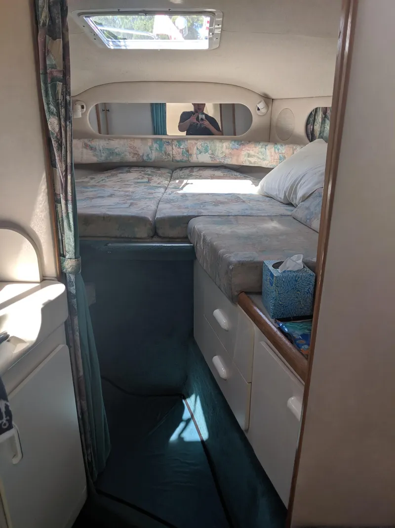 Slide: The Image of 1996 Sea Ray 290 Sundancer cabin interior with bed, storage, and natural light. - 10
