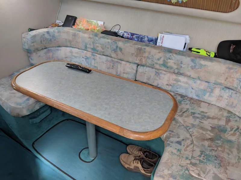 Slide: The Image of Interior of a 1996 Sea Ray 290 Sundancer with a cozy seating area and table. - 11
