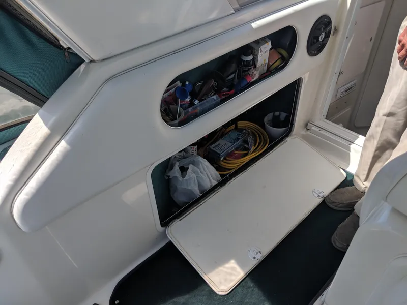 Slide: The Image of Storage compartment on a 1996 Sea Ray 290 Sundancer boat, containing various boating supplies. - 12