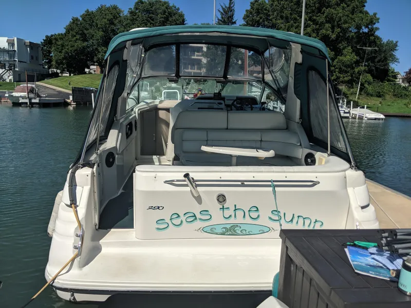 Slide: The Image of 1996 Sea Ray 290 Sundancer boat docked, featuring "Seas the Sumr" text on the stern. - 3