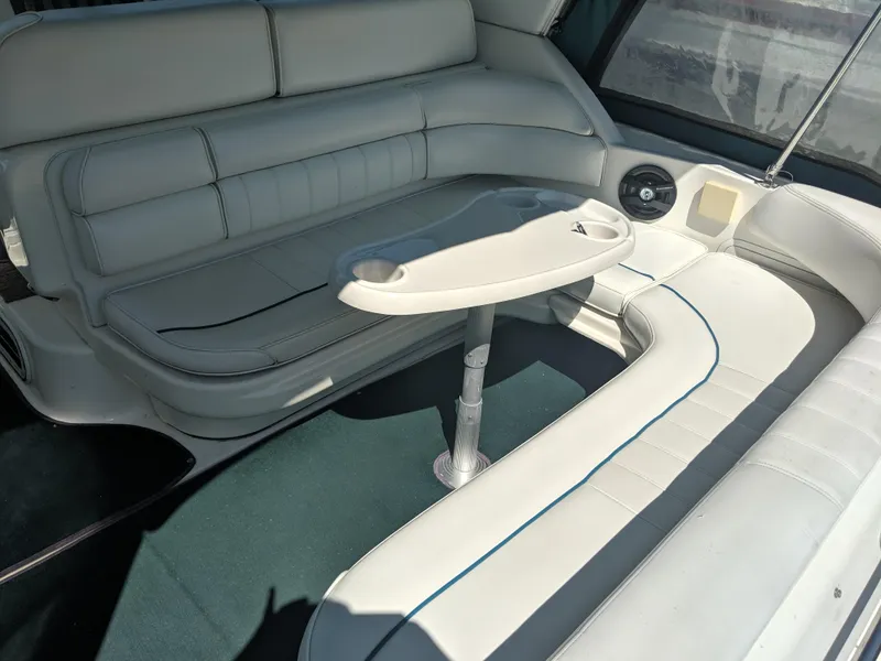 Slide: The Image of 1996 Sea Ray 290 Sundancer interior with white seating and a central table. - 4