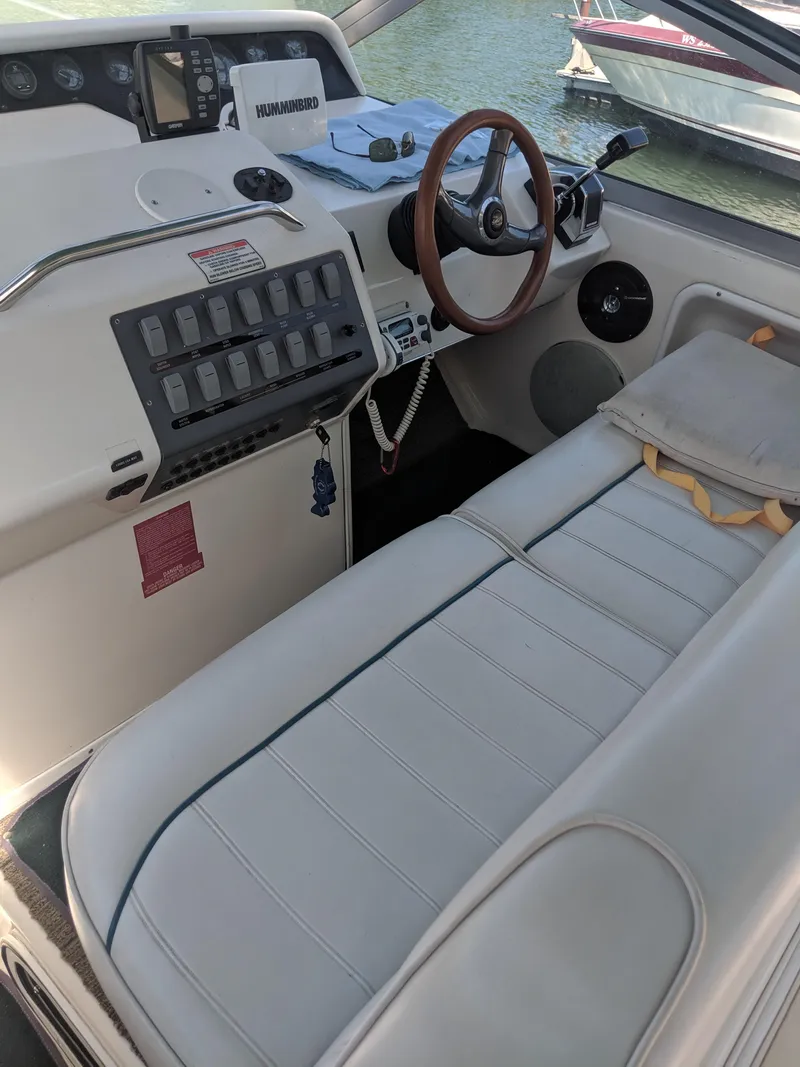 Slide: The Image of 1996 Sea Ray 290 Sundancer boat cockpit with steering wheel and control panel. - 5