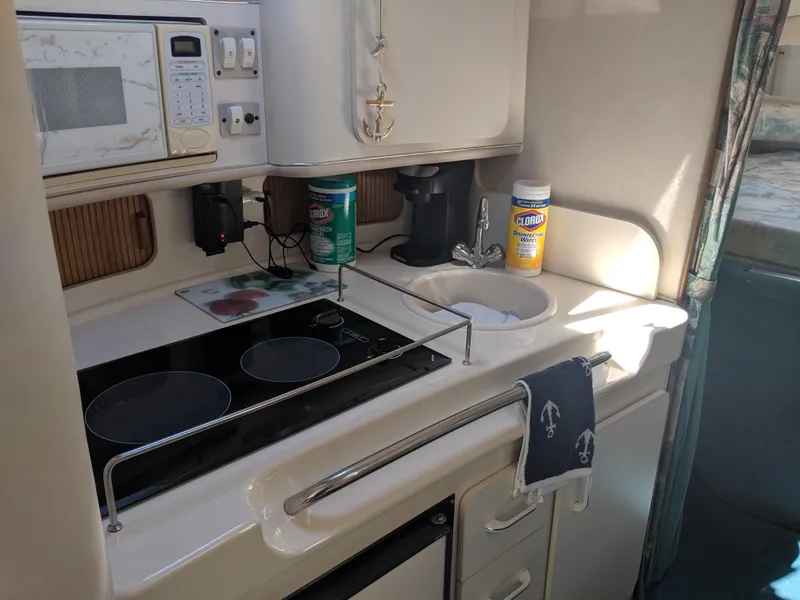 Slide: The Image of 1996 Sea Ray 290 Sundancer kitchen with stove, microwave, and sink. - 8