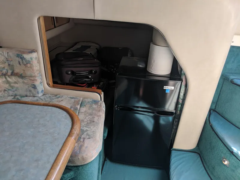 Slide: The Image of Interior of 1996 Sea Ray 290 Sundancer with mini fridge and seating area. - 9