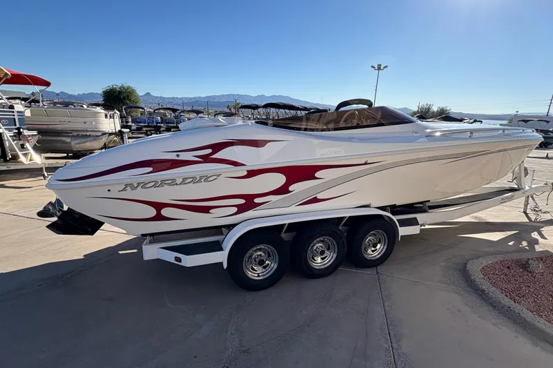 Slide: The Image of 2007 Nordic Boats 28 Heat with red flame design on trailer, parked outdoors. - 2
