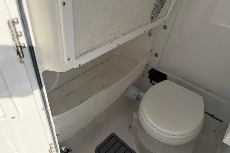 Slide: The Image of 2025 Sea Hunt Gamefish 27 boat interior with toilet and storage compartment. - 23