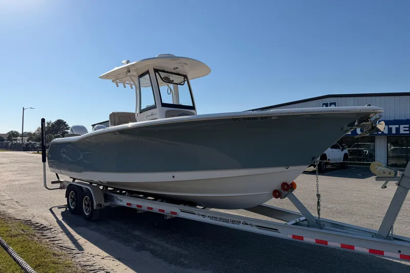 Slide: The Image of 2025 Sea Hunt Gamefish 27 Forward Seating boat on trailer in sunny outdoor setting. - 4