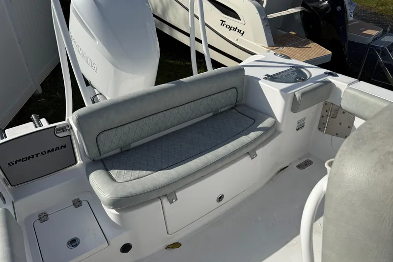 Slide: The Image of 2021 Sportsman Heritage 251 Center Console boat interior with cushioned seating and Yamaha engine. - 13