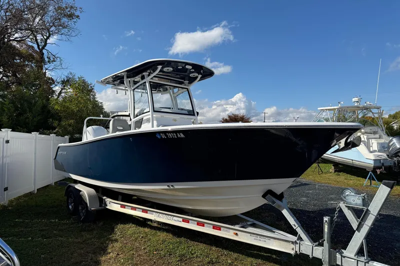 Slide: The Image of 2021 Sportsman Heritage 251 Center Console boat on trailer under clear blue sky. - 3