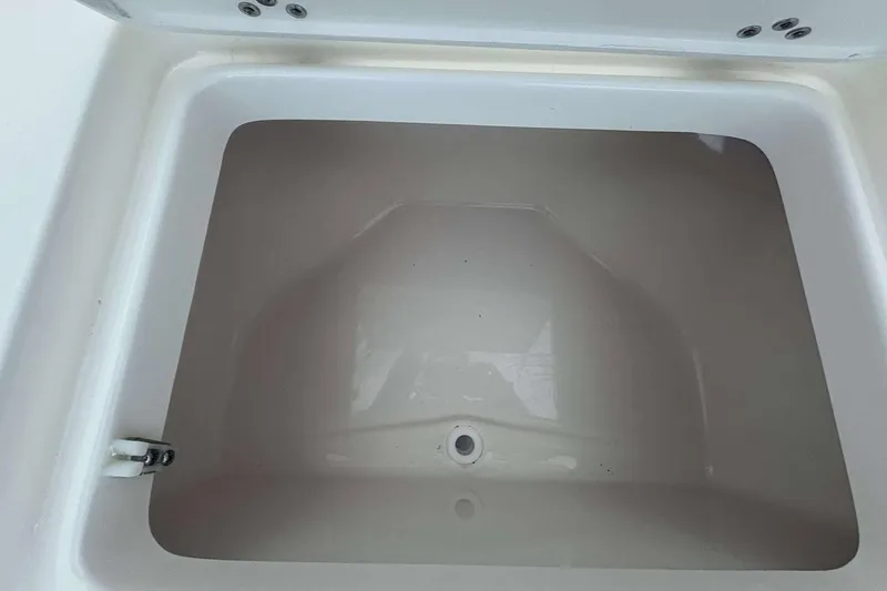 Slide: The Image of Key West 239 DFS 2026 boat storage compartment, white interior, open lid view. - 11