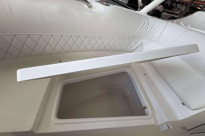 Slide: The Image of 2026 Key West 239 DFS boat interior with open storage compartment and cushioned seating. - 13