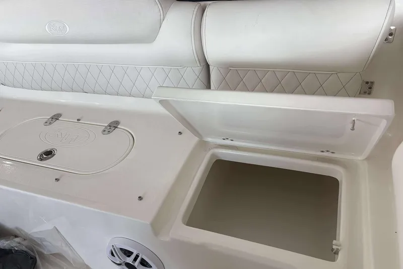 Slide: The Image of 2026 Key West 239 DFS boat interior with open storage compartment and cushioned seating. - 17