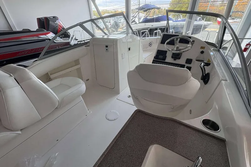 Slide: The Image of 2026 Key West 239 DFS boat interior with white seating and steering console. - 5