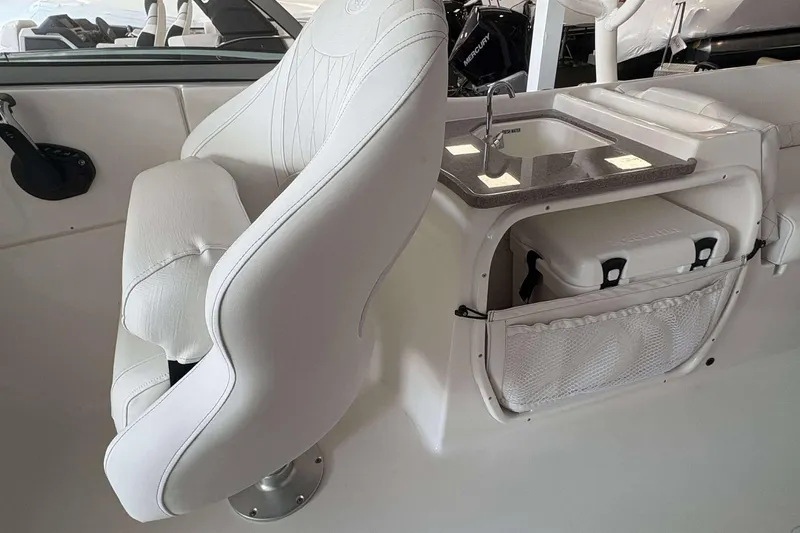 Slide: The Image of 2026 Key West 239 DFS boat interior with white seating and compact sink area. - 7