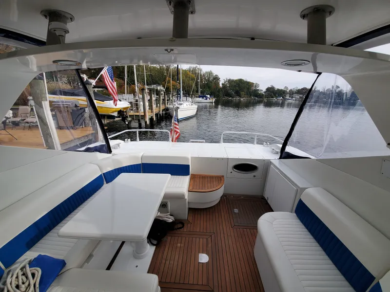 Slide: The Image of Interior of a 1993 Giorgi 46 yacht with white and blue seating, docked by a serene lake. - 10