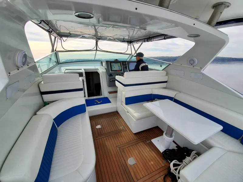 Slide: The Image of Luxurious 1993 Giorgi 46 yacht interior with white and blue seating, wooden flooring, and helm. - 6