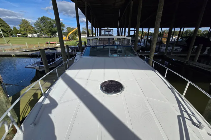 Slide: The Image of 1993 Giorgi 46 yacht docked under a covered marina, surrounded by boats and greenery. - 94