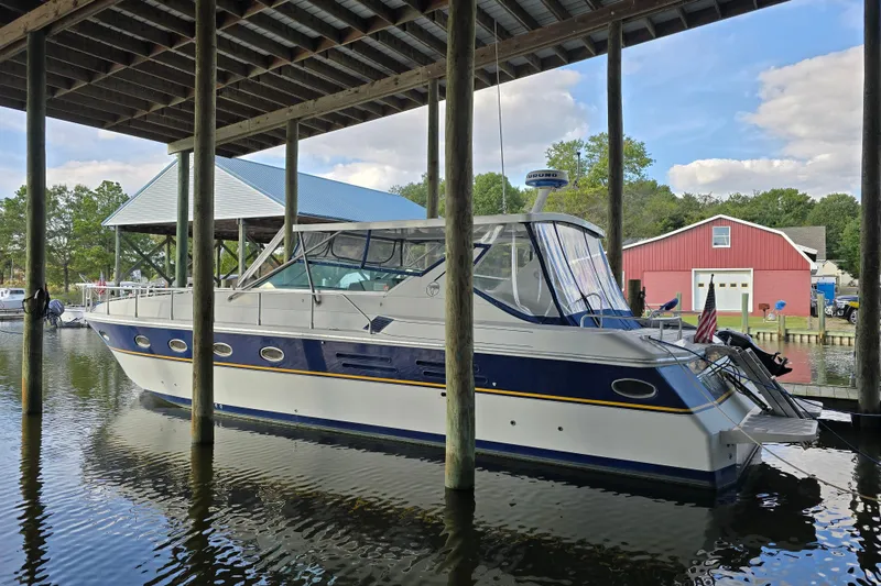 Slide: The Image of 1993 Giorgi 46 yacht docked under a covered marina with scenic background. - 96