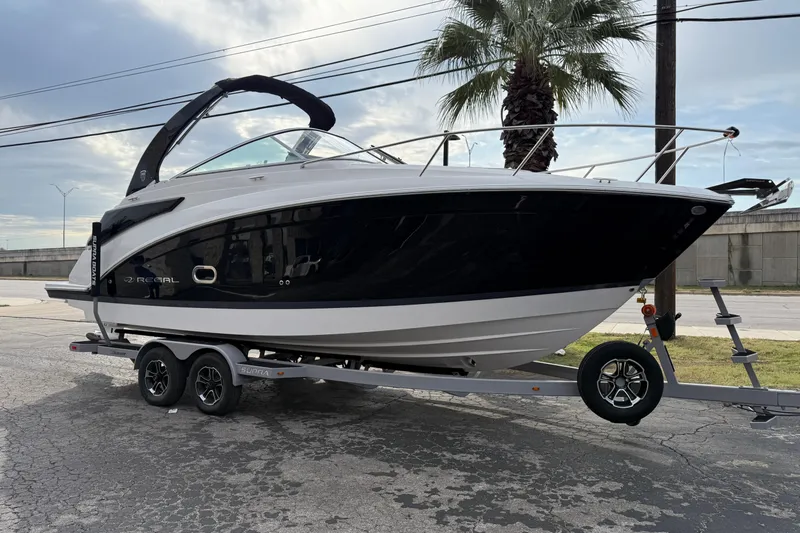 The Image of 2026 Regal 26 XO boat on trailer, parked outdoors near palm tree. - 0