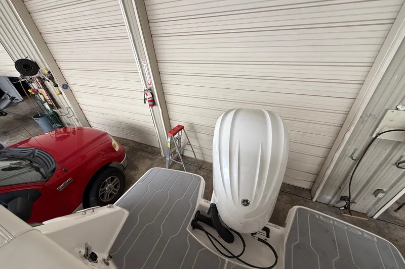 Slide: The Image of 2026 Regal 26 XO boat engine in a garage with a red car nearby. - 11