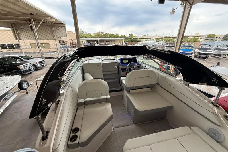 Slide: The Image of 2026 Regal 26 XO boat interior with seating and helm, docked at marina. - 13