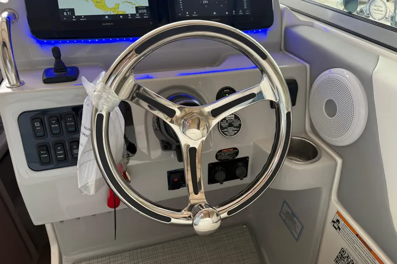 Slide: The Image of 2026 Regal 26 XO boat helm with chrome steering wheel and modern controls. - 22