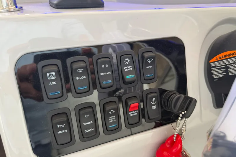 Slide: The Image of Control panel of 2026 Regal 26 XO boat with labeled switches and keychain. - 23