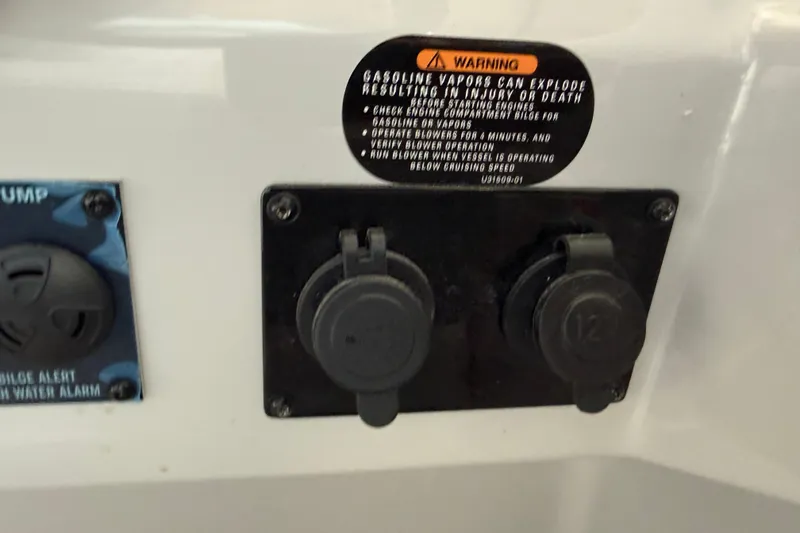 Slide: The Image of 2026 Regal 26 XO boat dashboard with warning label and electrical outlets. - 30