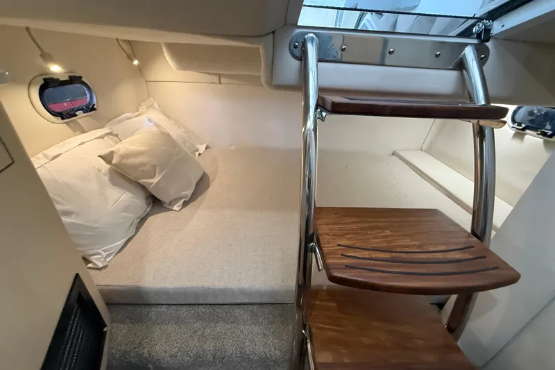 Slide: The Image of Cozy cabin interior of 2026 Regal 26 XO boat with wooden steps and bedding. - 32