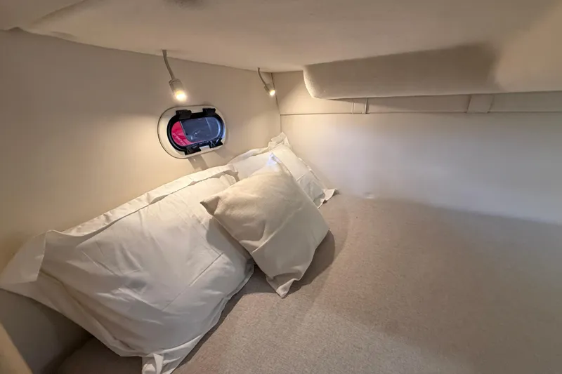 Slide: The Image of Cozy cabin interior of 2026 Regal 26 XO boat with soft lighting and pillows. - 33