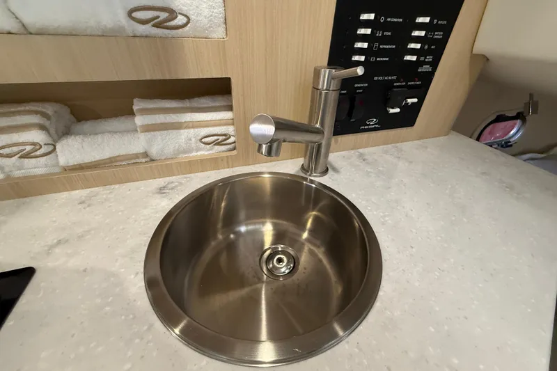 Slide: The Image of Stainless steel sink in 2026 Regal 26 XO boat interior with control panel and towels. - 41