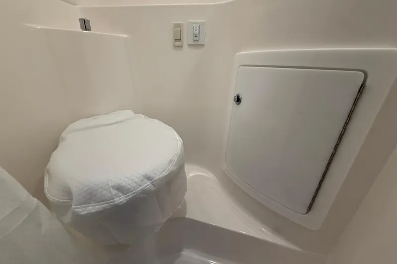 Slide: The Image of 2026 Regal 26 XO boat bathroom with compact toilet and storage compartment. - 42