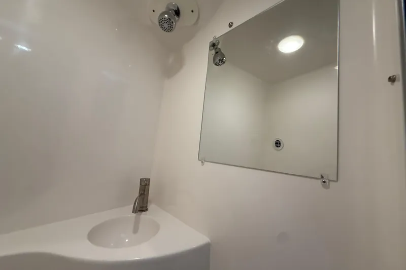 Slide: The Image of 2026 Regal 26 XO boat bathroom with sink, mirror, and showerhead. - 46
