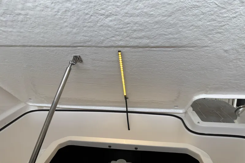 Slide: The Image of Interior view of 2026 Regal 26 XO boat with LED lighting and metal support rod. - 47