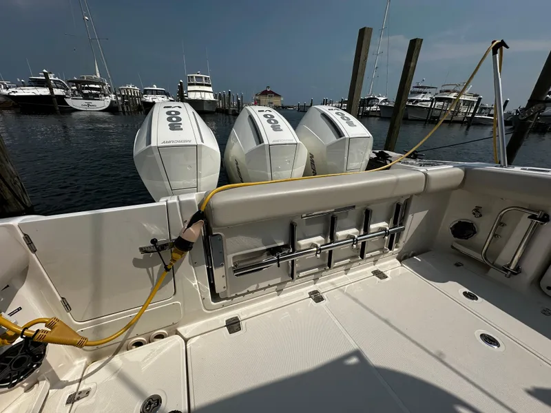 Slide: The Image of 2022 Boston Whaler 350 Realm with triple outboard engines docked at marina. - 10
