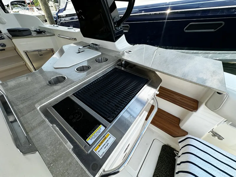 Slide: The Image of Outdoor kitchen on 2022 Boston Whaler 350 Realm boat with grill and cup holders. - 14