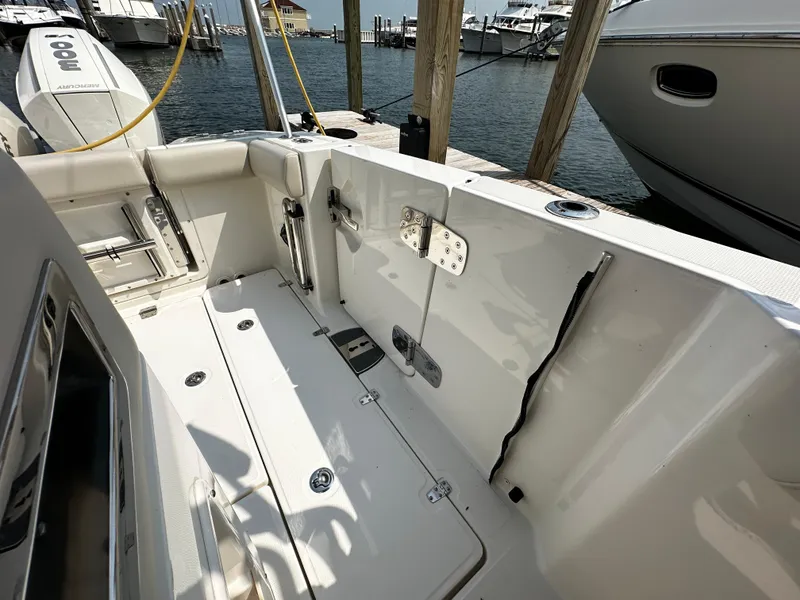 Slide: The Image of 2022 Boston Whaler 350 Realm boat interior, docked at marina with visible water and other boats. - 18