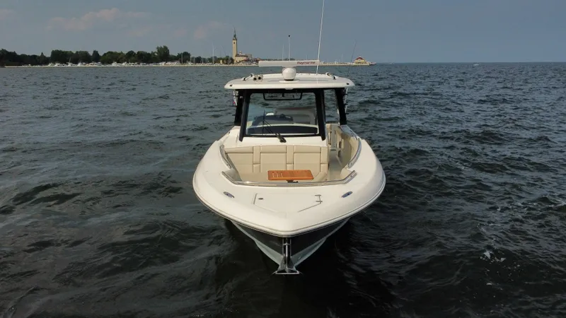 Slide: The Image of 2022 Boston Whaler 350 Realm boat on open water, distant shoreline in background. - 2