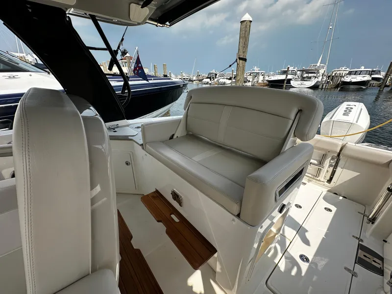 Slide: The Image of 2022 Boston Whaler 350 Realm interior with plush seating at marina. - 21