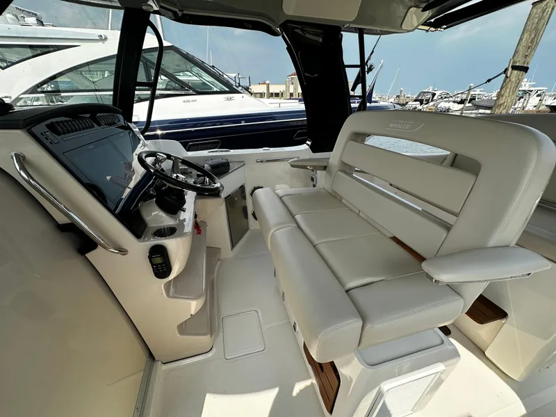 Slide: The Image of 2022 Boston Whaler 350 Realm interior with helm and seating, docked at marina. - 22