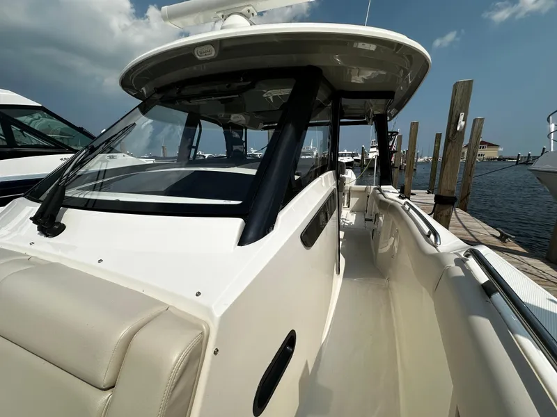 Slide: The Image of 2022 Boston Whaler 350 Realm boat docked at marina under clear sky. - 24
