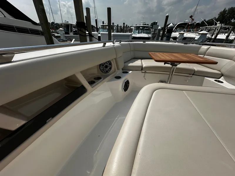 Slide: The Image of Boston Whaler 350 Realm 2022 boat interior with seating and wooden table. - 27