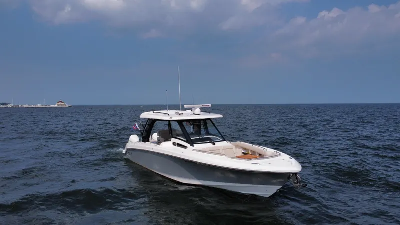 Slide: The Image of 2022 Boston Whaler 350 Realm boat cruising on open water under a cloudy sky. - 3
