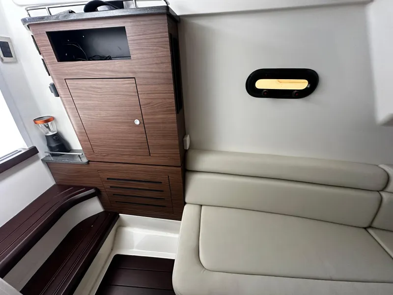 Slide: The Image of Interior of 2022 Boston Whaler 350 Realm, featuring wood cabinetry and cushioned seating. - 41