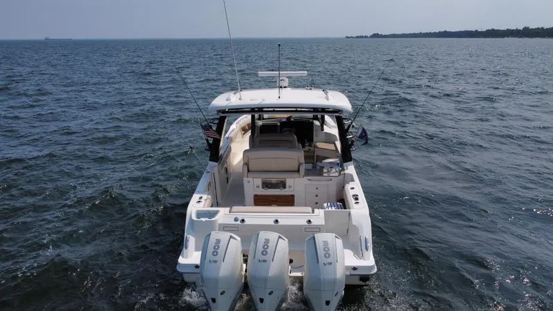 Slide: The Image of 2022 Boston Whaler 350 Realm boat cruising on open water, rear view. - 6