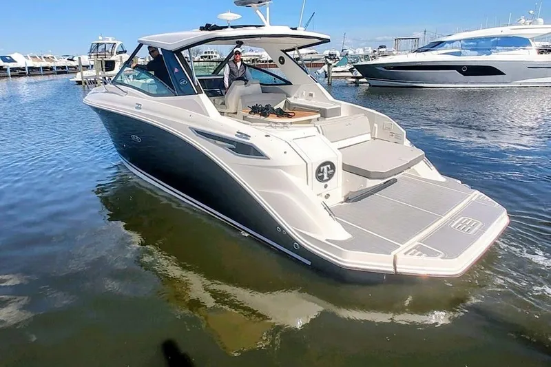 Slide: The Image of 2023 Sea Ray 320 Sundancer boat docked in marina, featuring sleek design and spacious deck. - 1