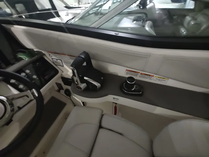 Slide: The Image of 2023 Sea Ray 320 Sundancer helm with modern controls and comfortable seating. - 14